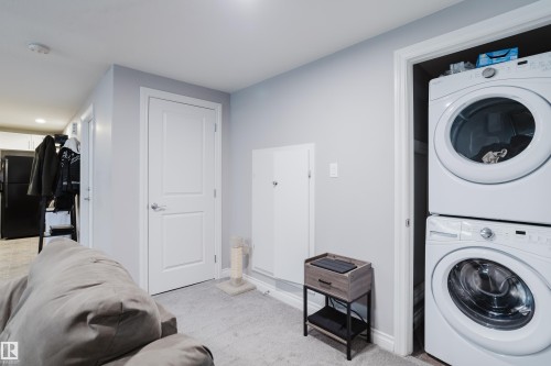 Laundry area featuring stacked washing machine and dryer, light colored carpet, and recessed lighting - 326 West Haven Drive, Leduc, AB - Indoor Photo Showing Laundry Room