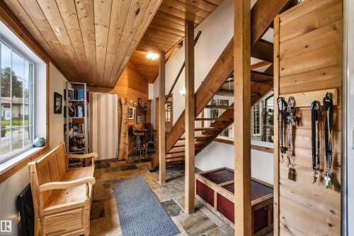 Living area featuring stone tile floors, wooden ceiling, and wooden walls - 605 6St. Ross Haven, Rural Lac Ste. Anne County, AB - Indoor Photo Showing Other Room