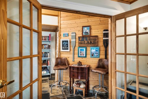 Home office featuring wood walls, dark stone finish floors, and french doors - 605 6St. Ross Haven, Rural Lac Ste. Anne County, AB - Indoor Photo Showing Other Room