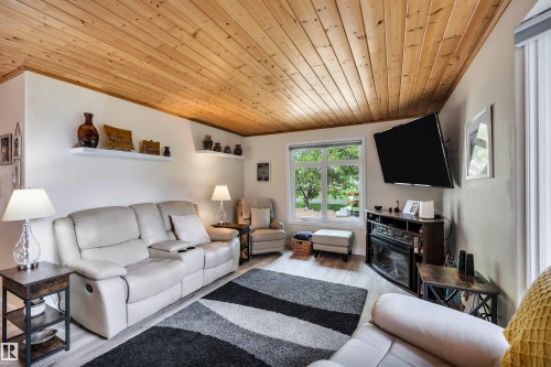 Living room featuring wood ceiling and wood finished floors - 605 6St. Ross Haven, Rural Lac Ste. Anne County, AB - Indoor Photo Showing Living Room