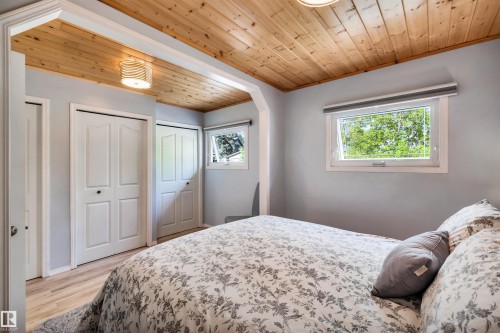 Bedroom featuring wood ceiling, multiple closets, and light wood-style flooring - 605 6St. Ross Haven, Rural Lac Ste. Anne County, AB - Indoor Photo Showing Bedroom