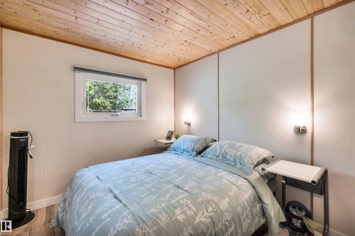 Bedroom featuring wooden ceiling and wood finished floors - 605 6St. Ross Haven, Rural Lac Ste. Anne County, AB - Indoor Photo Showing Bedroom