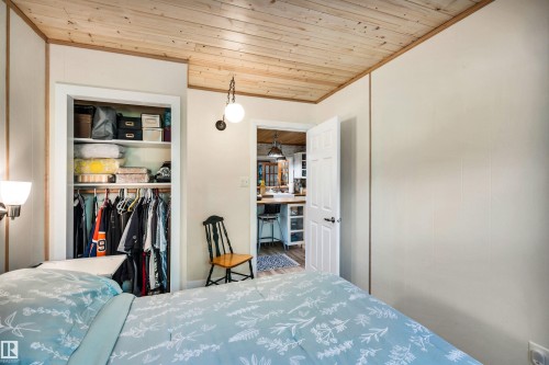 Bedroom featuring wooden ceiling, ornamental molding, and a closet - 605 6St. Ross Haven, Rural Lac Ste. Anne County, AB - Indoor Photo Showing Bedroom