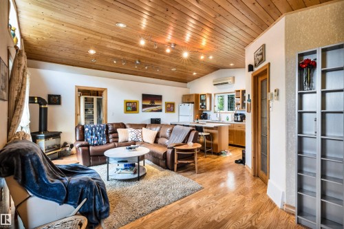 Living room with a vaulted wood ceiling, light wood-style flooring, recessed lighting, and a wood stove - 605 6St. Ross Haven, Rural Lac Ste. Anne County, AB - Indoor Photo Showing Living Room