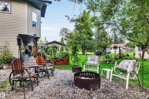 View of grassy yard featuring a fire pit and a patio - 605 6St. Ross Haven, Rural Lac Ste. Anne County, AB - Outdoor