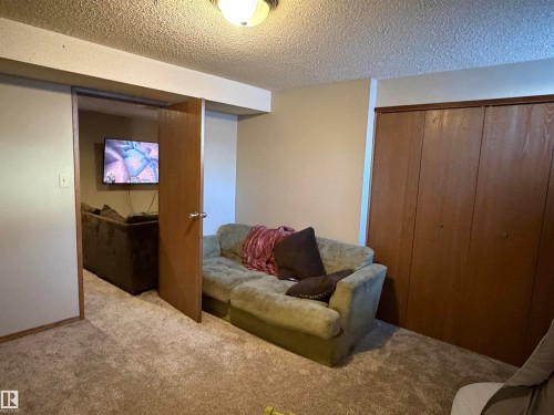 Living area with a textured ceiling and carpet floors - 2008 4Th Ave, Cold Lake, AB - Indoor