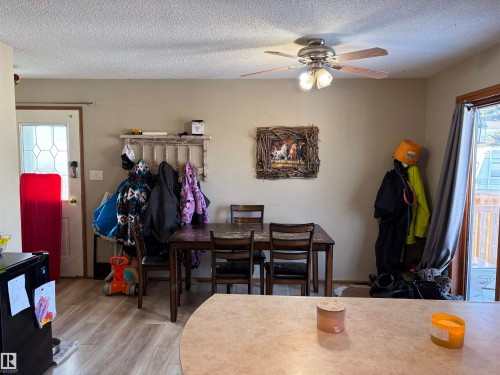 Dining area featuring healthy amount of natural light, light wood-type flooring, a ceiling fan, and a textured ceiling - 2008 4Th Ave, Cold Lake, AB - Indoor Photo Showing Dining Room