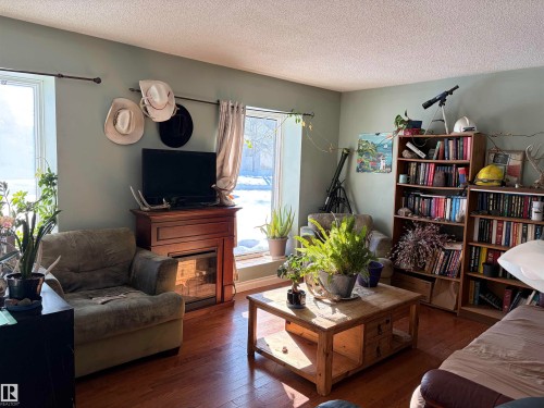 Living room with hardwood / wood-style flooring and a textured ceiling - 2008 4Th Ave, Cold Lake, AB - Indoor Photo Showing Living Room With Fireplace