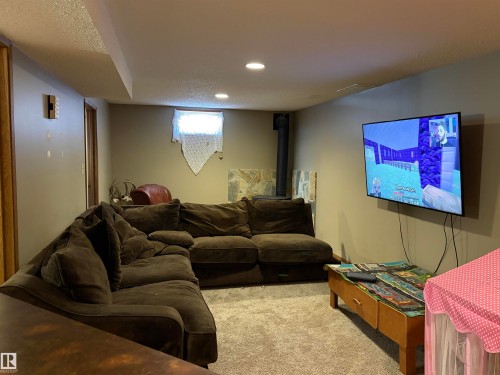 Carpeted living area featuring a textured ceiling and recessed lighting - 2008 4Th Ave, Cold Lake, AB - Indoor Photo Showing Basement