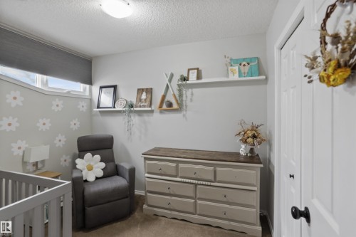 Carpeted bedroom with a crib, a closet, and a textured ceiling - 7 Chungo Drive, Devon, AB - Indoor