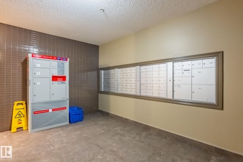 Surrounding community featuring mail area, a textured ceiling, and tile walls - 207 2203 44 Avenue, Edmonton, AB - Indoor