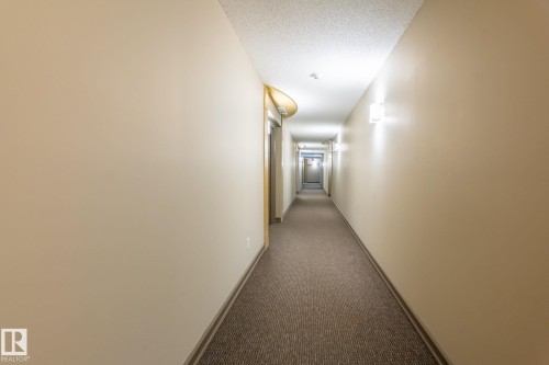 Corridor with dark colored carpet and a textured ceiling - 207 2203 44 Avenue, Edmonton, AB - Indoor Photo Showing Other Room