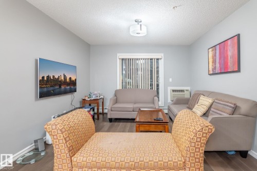 Living room featuring dark wood-style floors and a textured ceiling - 207 2203 44 Avenue, Edmonton, AB - Indoor Photo Showing Living Room