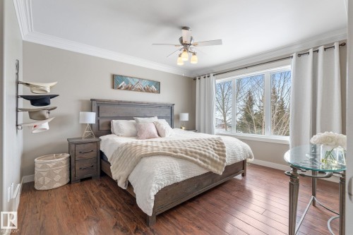 Bedroom featuring ornamental molding, dark wood-style floors, and a ceiling fan - 523 55101 Ste. Anne Trail, Rural Lac Ste. Anne County, AB - Indoor Photo Showing Bedroom