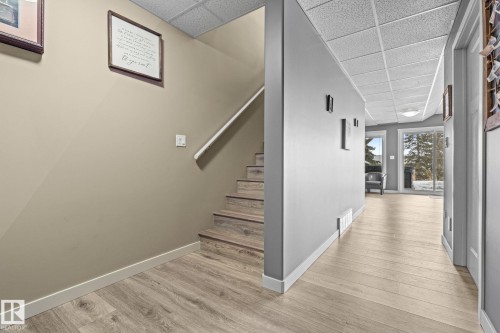 Staircase with a drop ceiling and wood finished floors - 523 55101 Ste. Anne Trail, Rural Lac Ste. Anne County, AB - Indoor Photo Showing Other Room