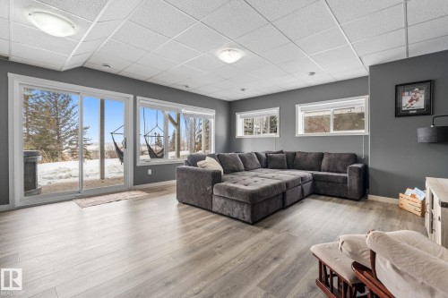 Living room with a paneled ceiling and light wood-style flooring - 523 55101 Ste. Anne Trail, Rural Lac Ste. Anne County, AB - Indoor Photo Showing Living Room