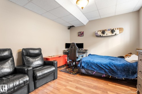 Bedroom with a drop ceiling, light wood-style floors, and an office area - 523 55101 Ste. Anne Trail, Rural Lac Ste. Anne County, AB - Indoor Photo Showing Bedroom