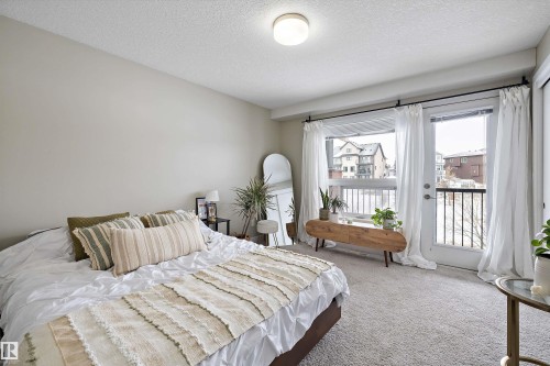 Bedroom featuring carpet, a textured ceiling, and access to outside - 94 2560 Pegasus Boulevard, Edmonton, AB - Indoor Photo Showing Bedroom