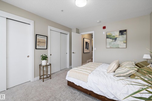 Bedroom featuring multiple closets, light carpet, and a textured ceiling - 94 2560 Pegasus Boulevard, Edmonton, AB - Indoor Photo Showing Bedroom