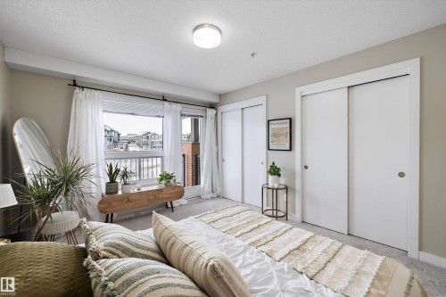 Bedroom with two closets, carpet, and a textured ceiling - 94 2560 Pegasus Boulevard, Edmonton, AB - Indoor