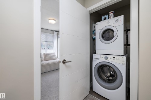 Laundry area with light colored carpet and stacked washer / drying machine - 94 2560 Pegasus Boulevard, Edmonton, AB - Indoor Photo Showing Laundry Room