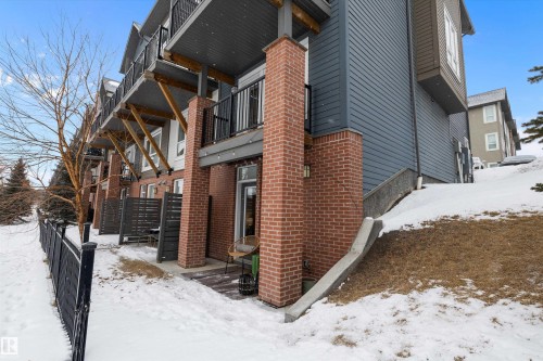 Snow covered property with brick siding and a balcony - 94 2560 Pegasus Boulevard, Edmonton, AB - Outdoor