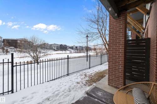 Yard covered in snow featuring a patio area and a residential view - 94 2560 Pegasus Boulevard, Edmonton, AB - Outdoor