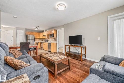 Living area featuring dark wood-type flooring and baseboards - 221 5005 165 Avenue, Edmonton, AB - Indoor Photo Showing Living Room