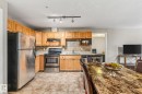 Kitchen with stainless steel appliances, tasteful backsplash, rail lighting, and light tile patterned flooring - 221 5005 165 Avenue, Edmonton, AB  - Indoor Photo Showing Kitchen With Double Sink 
