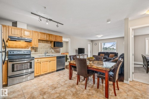 Kitchen with stainless steel appliances, tasteful backsplash, light countertops, track lighting, and light wood finish cabinets - 221 5005 165 Avenue, Edmonton, AB - Indoor