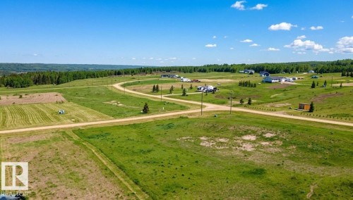 Expansive undeveloped land featuring rolling green hills and a distant tree line - 30 River Ridge Estates, Rural Wetaskiwin County, AB 