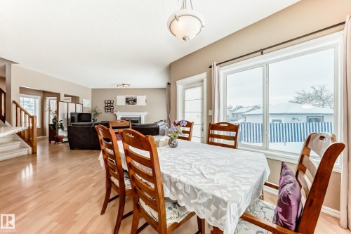 Dining room with a fireplace and light wood-type flooring - 4619 151 Avenue Nw, Edmonton, AB - Indoor Photo Showing Dining Room