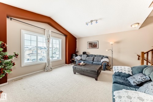 Living area with carpet flooring and vaulted ceiling - 4619 151 Avenue Nw, Edmonton, AB - Indoor Photo Showing Living Room