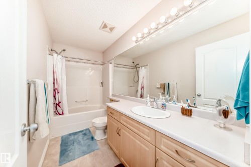 Full bathroom with vanity, shower / tub combo, and light tile patterned flooring - 4619 151 Avenue Nw, Edmonton, AB - Indoor Photo Showing Bathroom