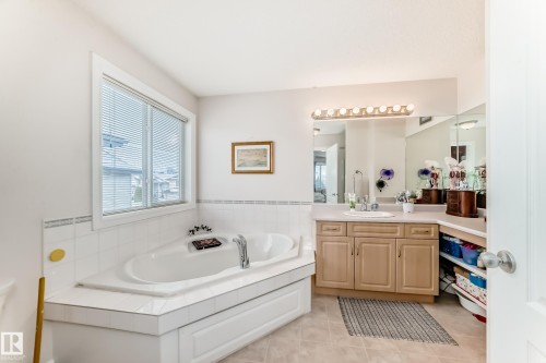 Bathroom with vanity, a garden tub, and light tile patterned floors - 4619 151 Avenue Nw, Edmonton, AB - Indoor Photo Showing Bathroom