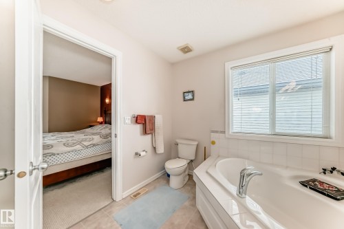 Ensuite bathroom featuring a garden tub and light tile patterned flooring - 4619 151 Avenue Nw, Edmonton, AB - Indoor Photo Showing Bathroom