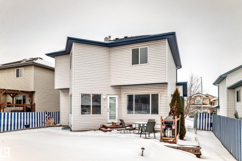 Snow covered back of property featuring a patio and outdoor dining space - 4619 151 Avenue Nw, Edmonton, AB - Outdoor With Exterior