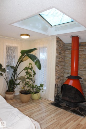 Detailed view of wood finished floors, a skylight, and a textured ceiling - 12432 134 Street, Edmonton, AB - Indoor With Fireplace