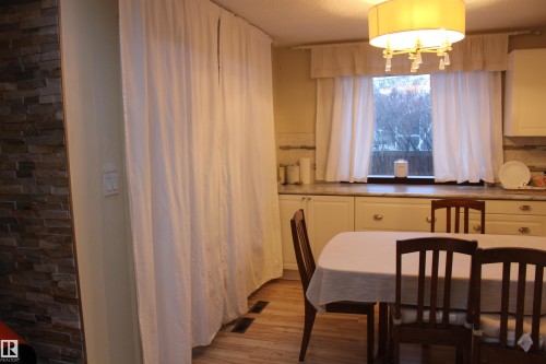 Dining space featuring light wood-type flooring, suspended lighting, and a textured ceiling - 12432 134 Street, Edmonton, AB - Indoor Photo Showing Dining Room