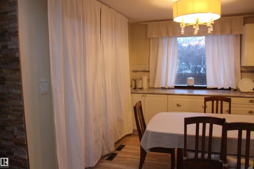 Dining space with light wood-style flooring, suspended lighting, and a textured ceiling - 12432 134 Street, Edmonton, AB - Indoor Photo Showing Dining Room