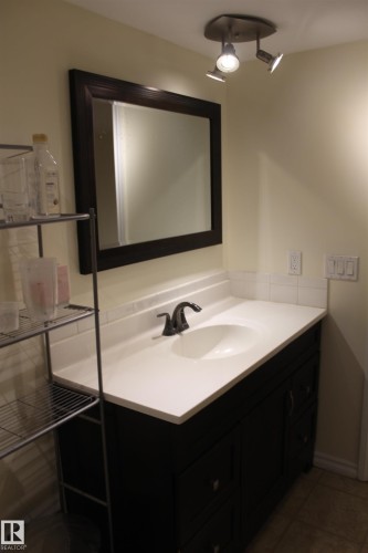 Bathroom featuring vanity and dark tile patterned flooring - 12432 134 Street, Edmonton, AB - Indoor Photo Showing Bathroom
