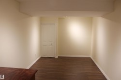 Empty room featuring dark wood-type flooring and baseboards - 