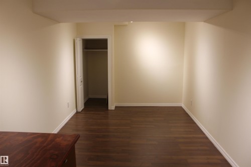 Unfurnished bedroom featuring dark wood finished floors and a closet - 12432 134 Street, Edmonton, AB - Indoor Photo Showing Other Room