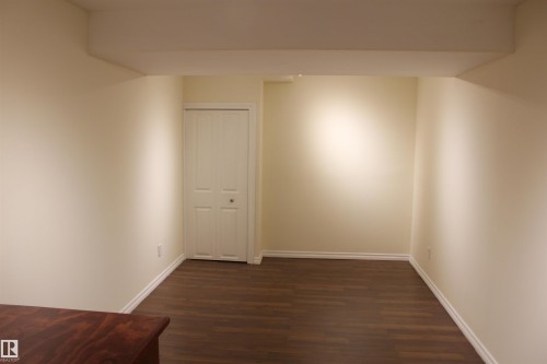 Empty room featuring dark wood-type flooring and baseboards - 12432 134 Street, Edmonton, AB - Indoor Photo Showing Other Room