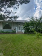 View of front of house with a front lawn and a shingled roof - 