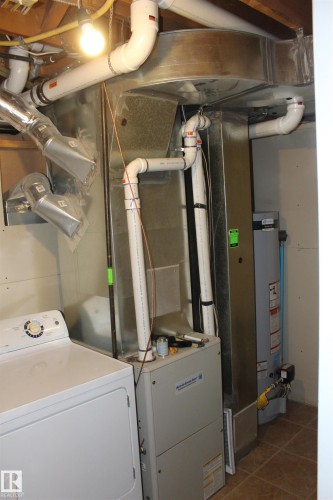 Utilities featuring washer / dryer, heating unit, and water heater - 12432 134 Street, Edmonton, AB - Indoor