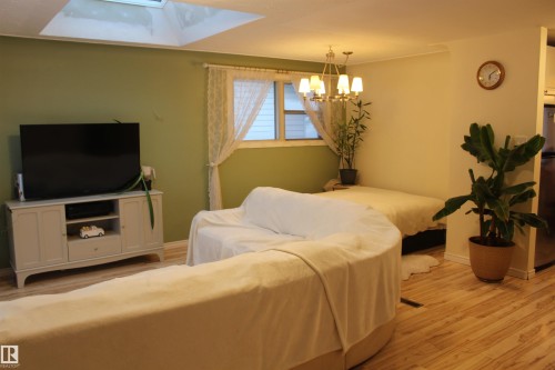 Living room with light wood finished floors and suspended lighting - 12432 134 Street, Edmonton, AB - Indoor