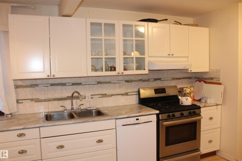Kitchen featuring stainless steel range with gas stovetop, light countertops, white cabinetry, and dishwasher - 12432 134 Street, Edmonton, AB - Indoor Photo Showing Kitchen With Double Sink