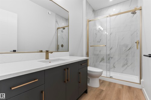 Full bathroom with vanity, a marble finish shower, and light wood-style floors - 523 Ashgrove Circle, Leduc, AB - Indoor Photo Showing Bathroom