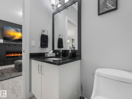 Bathroom with a lit fireplace and vanity - 3510 48 Avenue, Beaumont, AB - Indoor Photo Showing Bathroom